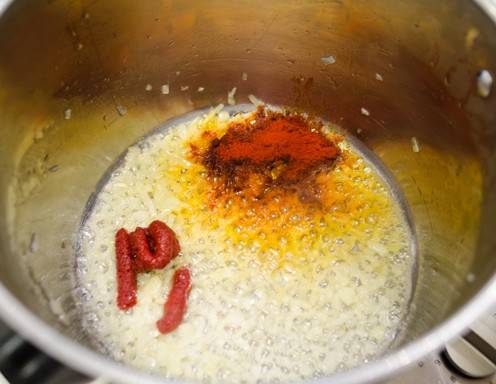 In einer Pfanne die Butter zum Schmelzen bringen und die Zwiebel darin kräftig anrösten. Mit Paprika