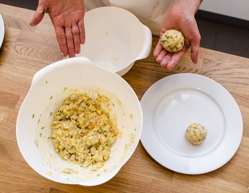 Aus der Knödelmasse mit feuchten Hände runde Semmelknödel formen und sie ca. 10 Minuten in siedendem