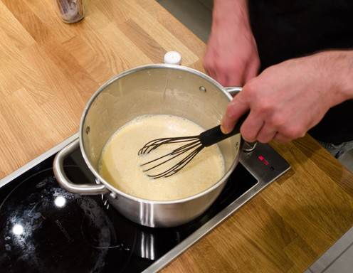 Die Puddingmischung in die heiße Milch einrühren.