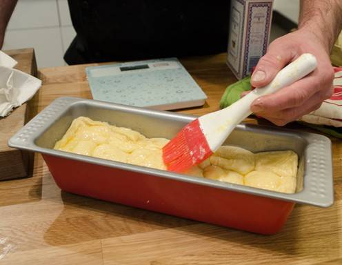 Die Buchteln mit flüssiger Butter bestreichen.