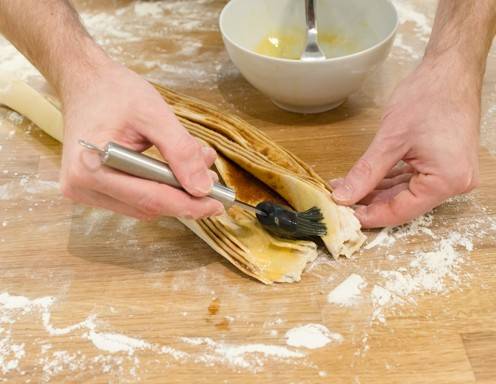 Die Enden mit Butter bestreichen.