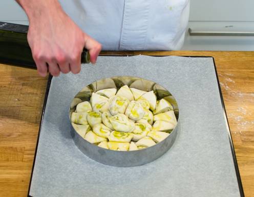 Beträufeln Sie die Pizza-Blume mit Olivenöl