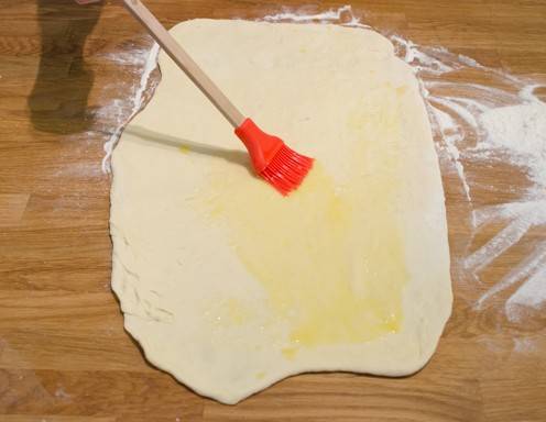 Bepinseln Sie den Teig mit Butter