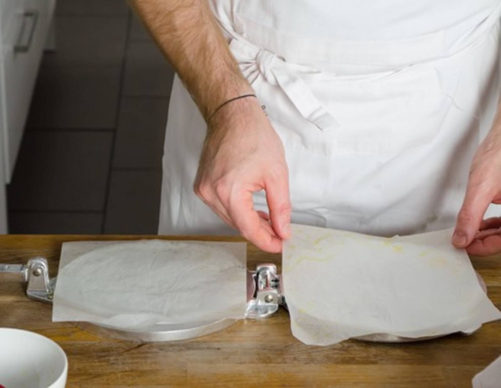 Tortillapresse mit Backpapier auslegen